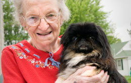 elderly woman with dog in her arms.